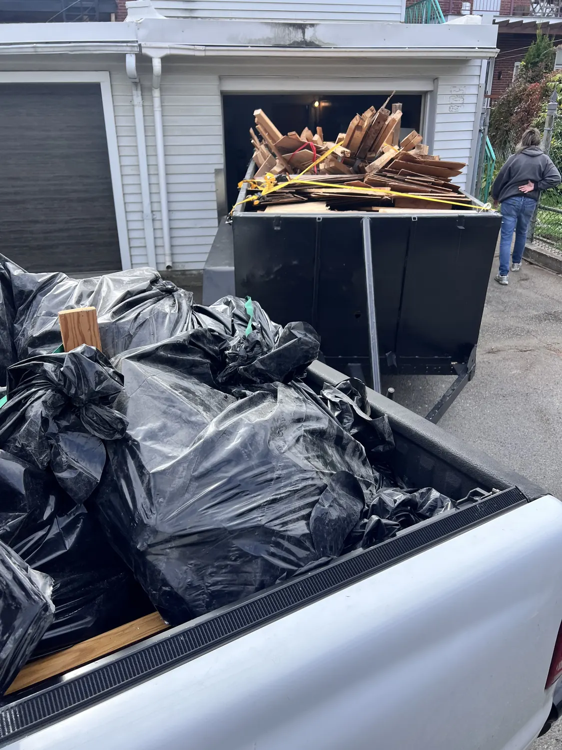 Sacs de rebuts dans la boîte du camion, bois sanglé dans la remorque